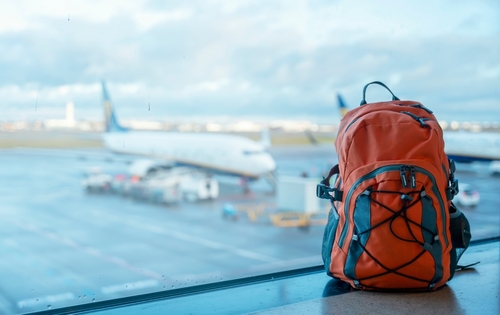 Orange,Backpack,In,An,Airport,Against,A,Plane.,Travel,Touristic mochila viaje avión - Imagen 1